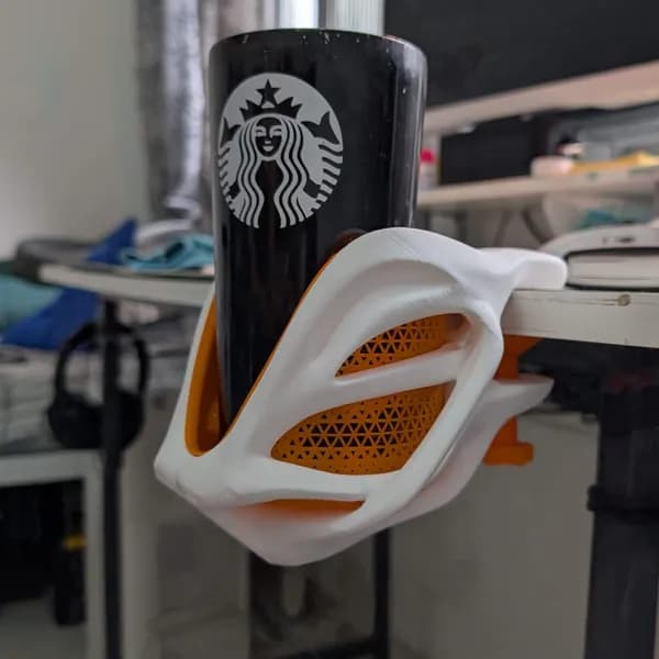 Desk cup holder clipped to monitor with a Starbucks mug