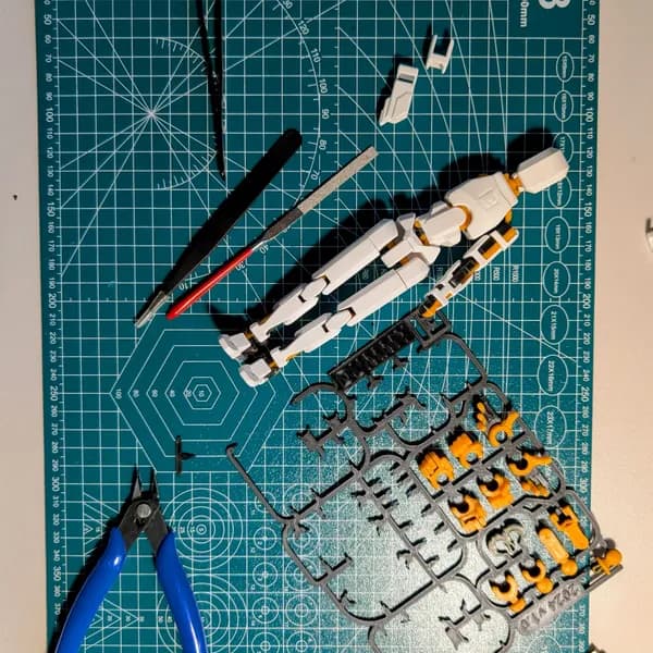 Gundam figure build laid out on a cutting mat with tools