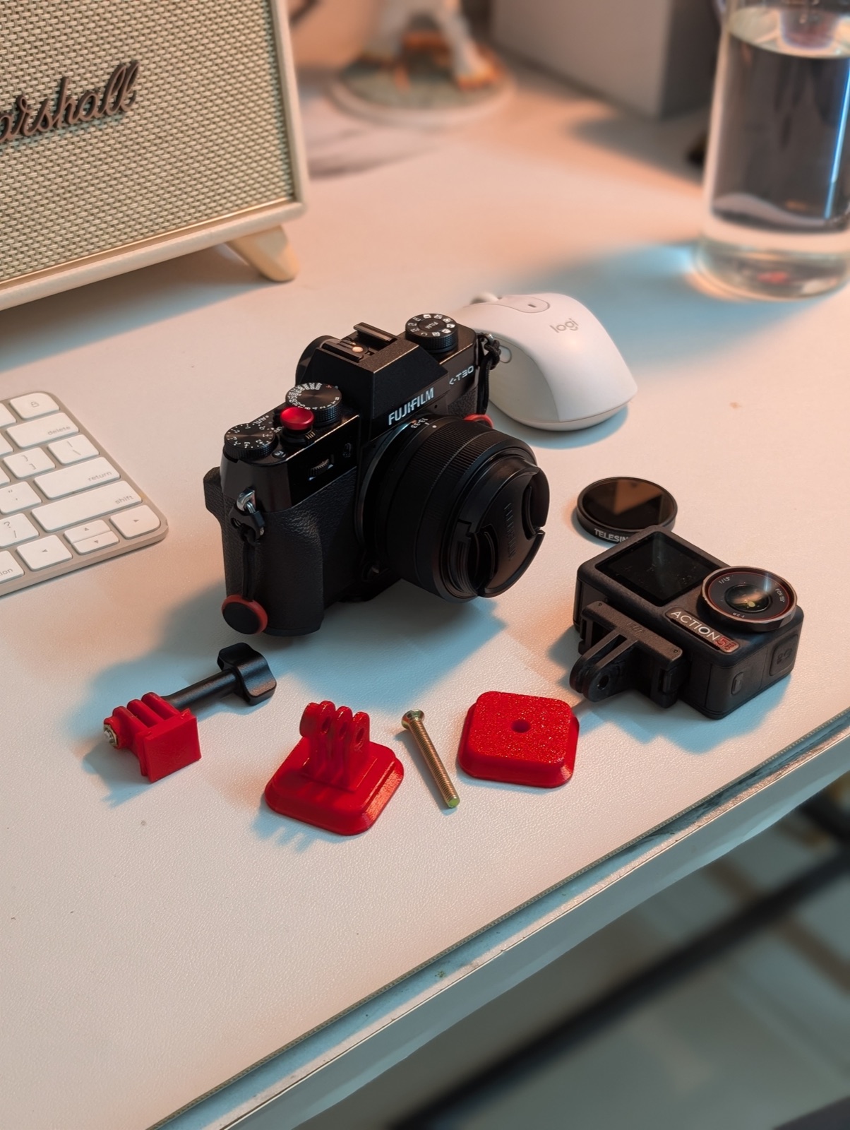 All the printed pieces laid out next to the Fujifilm and the DJI Action 5 Pro