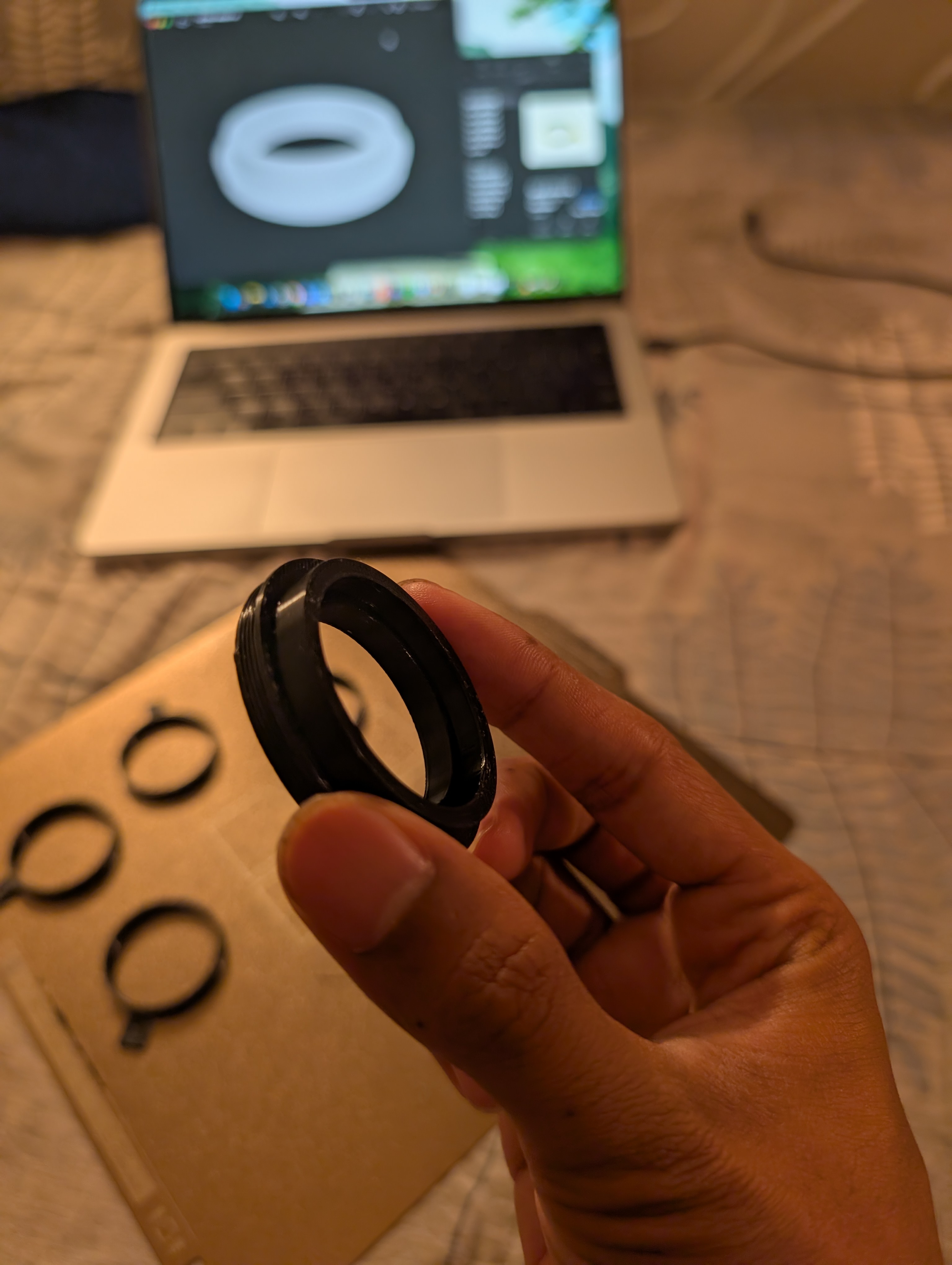 The printed adapter in hand, with the fit-test rings and CAD model behind.