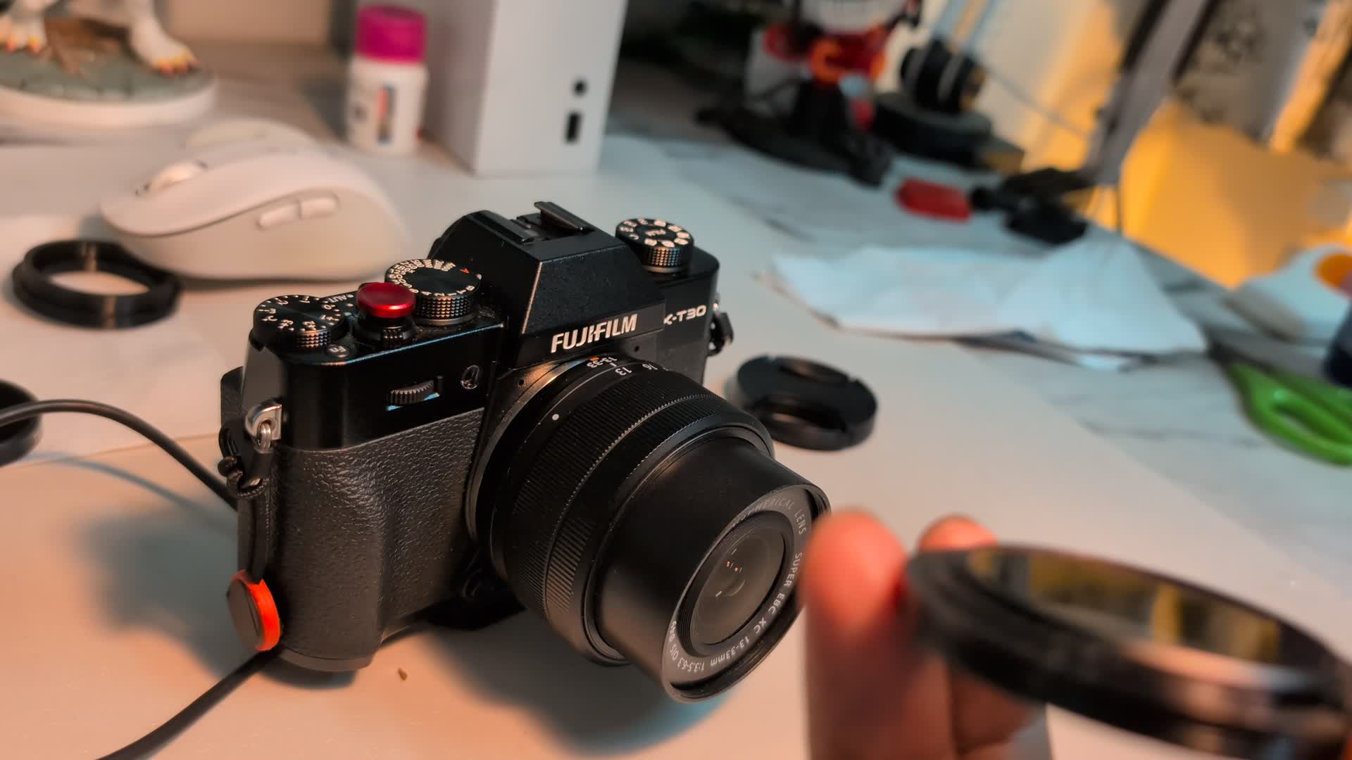 The 3D-printed adapter being fitted onto the Fujifilm kit lens.