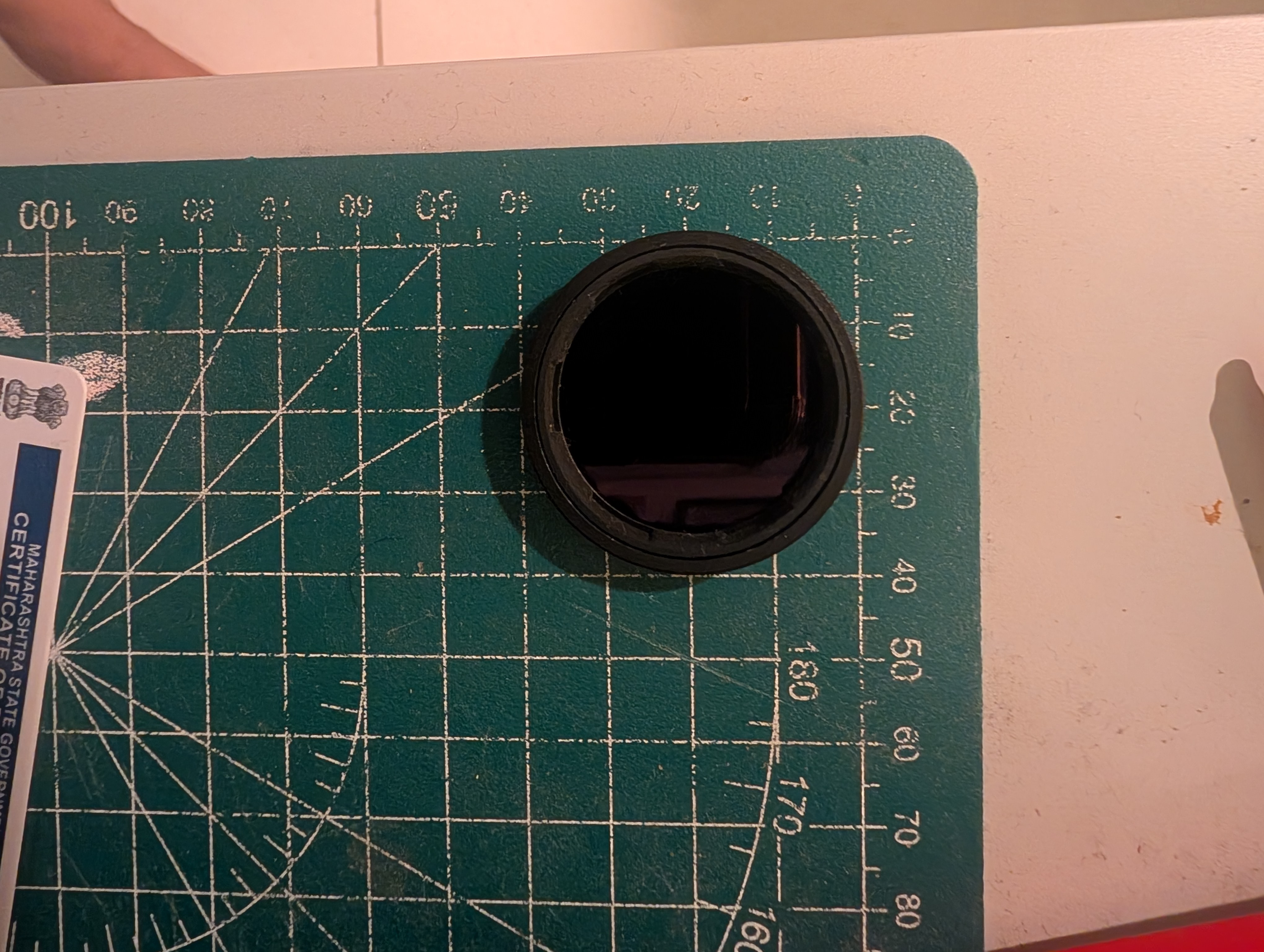 The DJI Osmo Action push-on ND/CPL filter, measured on a cutting mat.