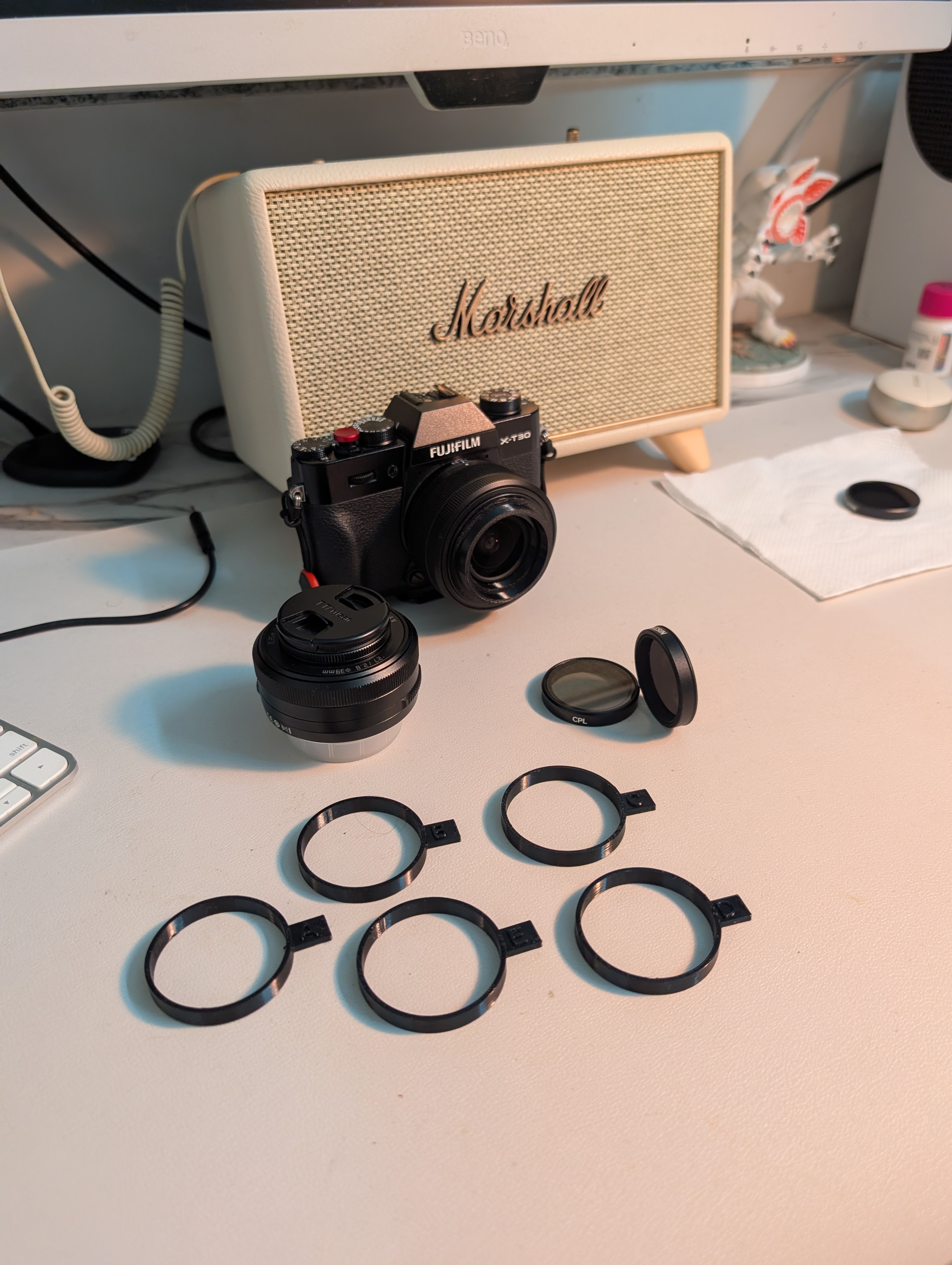 A Fujifilm X-T30 III with the XC13-33mm kit lens, a DJI Osmo Action CPL/ND filter, and five printed fit-test rings.